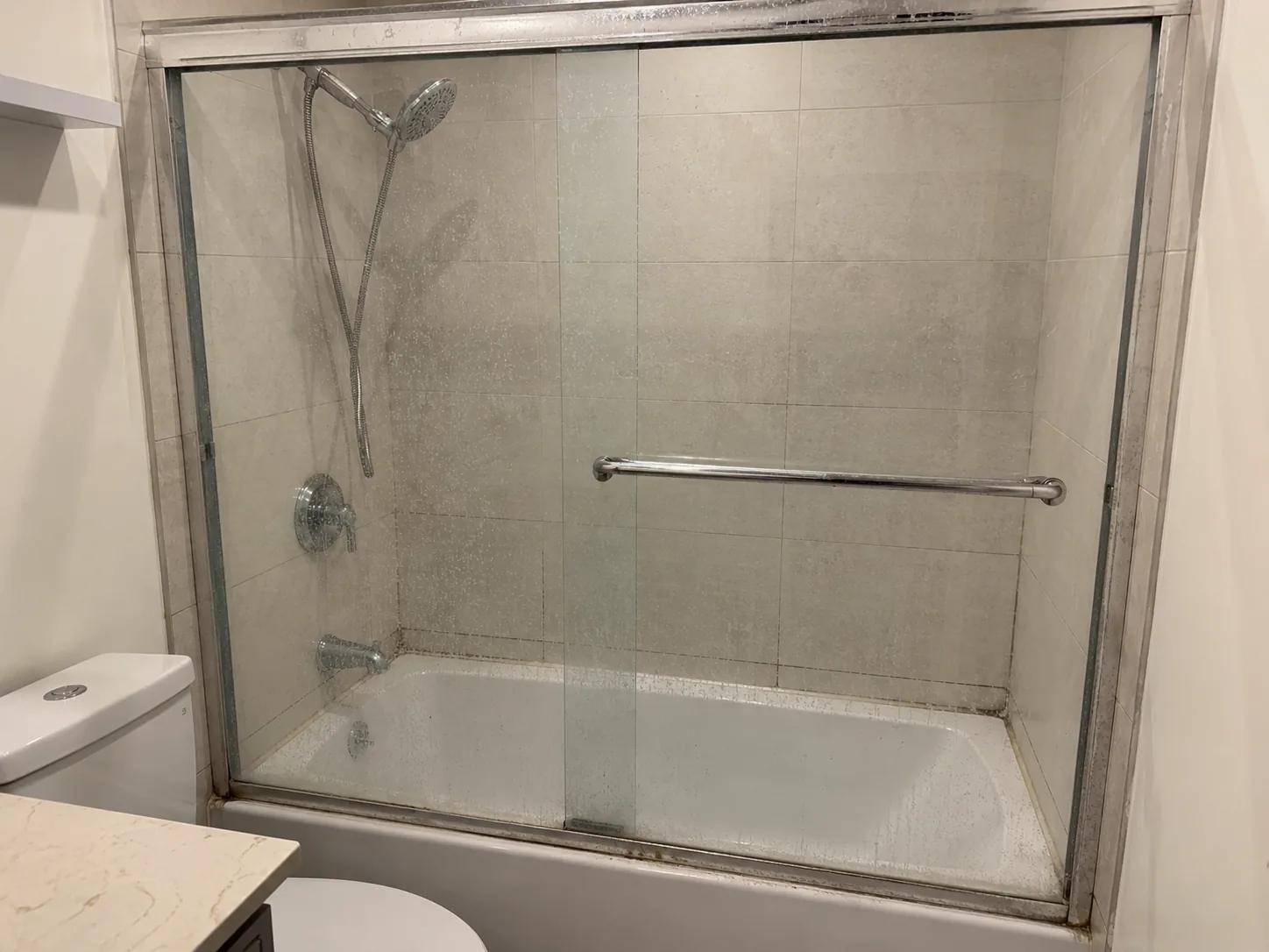 Before: Clean bathtub shower glass after full shower refresh service in Vancouver